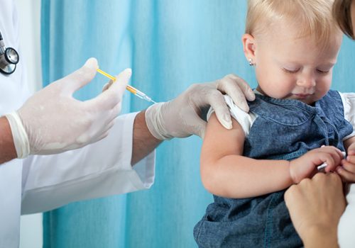 Pediatrician makes vaccination to small girl
